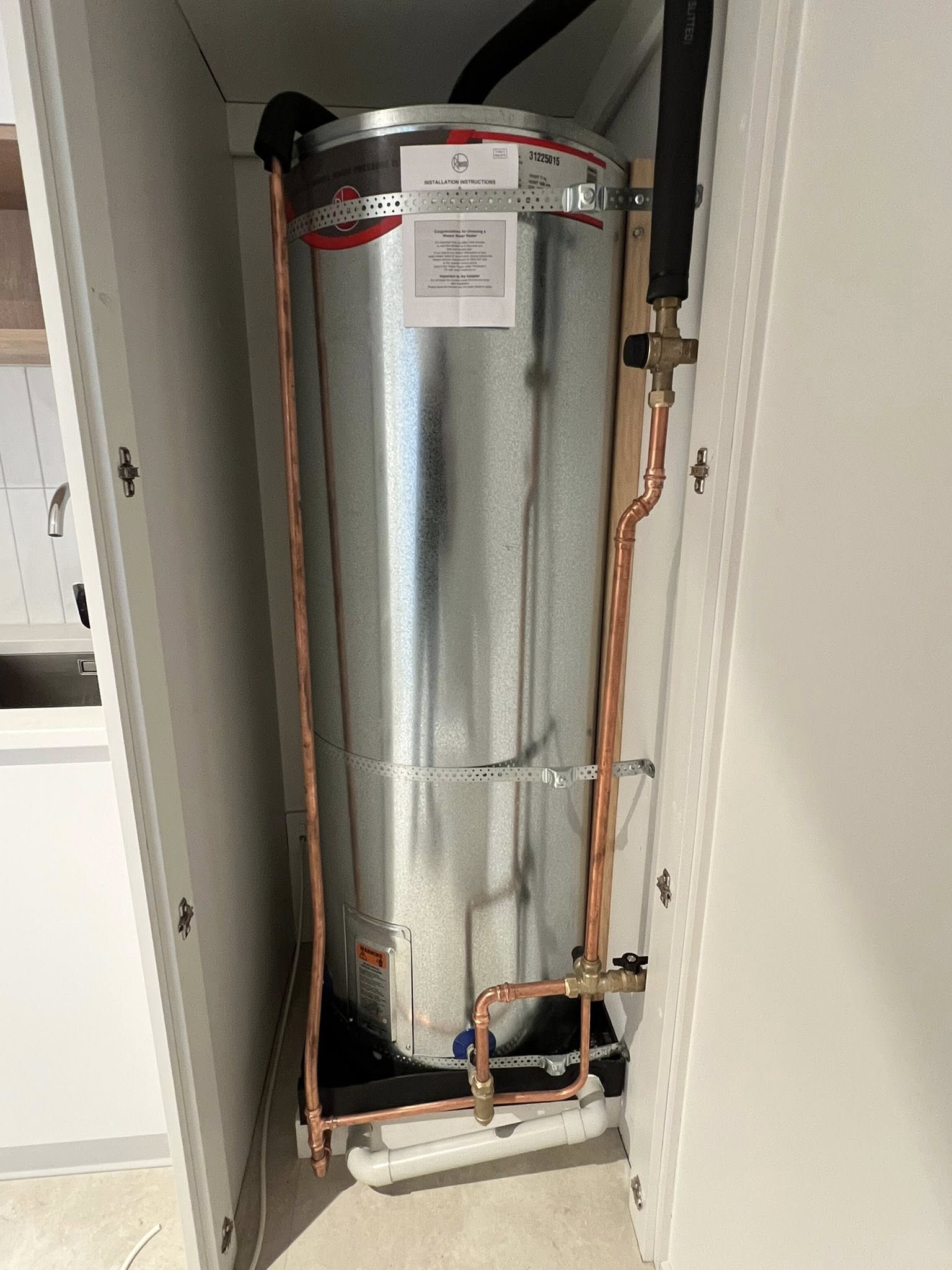 Brand-new Rheem cylinder installed indoors with full copper pipework and installation paperwork