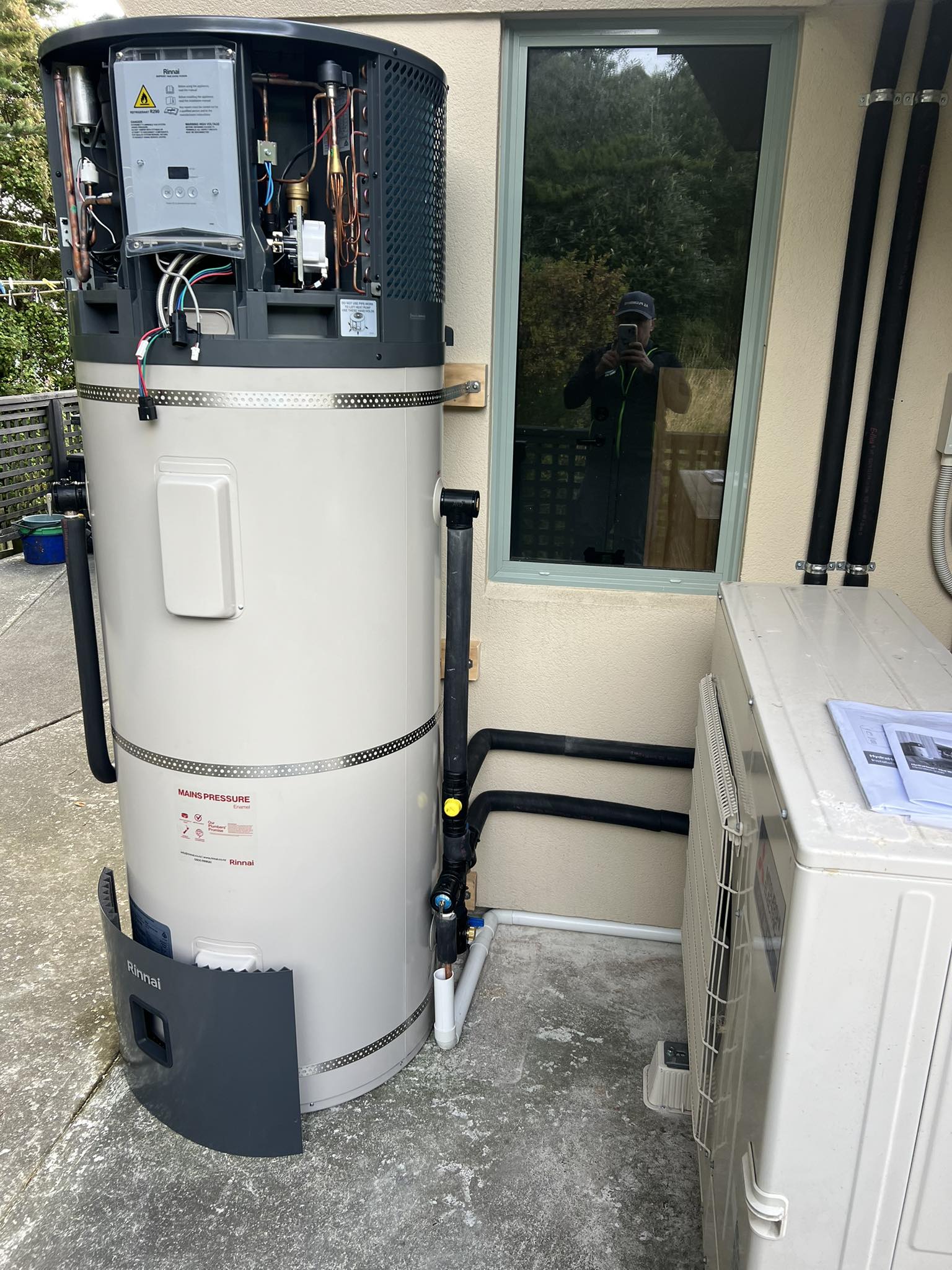 Rheem mains pressure heat pump hot water unit installed outside a Christchurch home